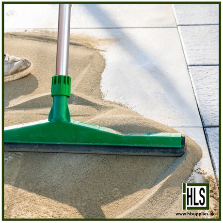 HLSupplies TuffJoint Utility brush-in grout being swept into paving joints with a green squeegee on a patio